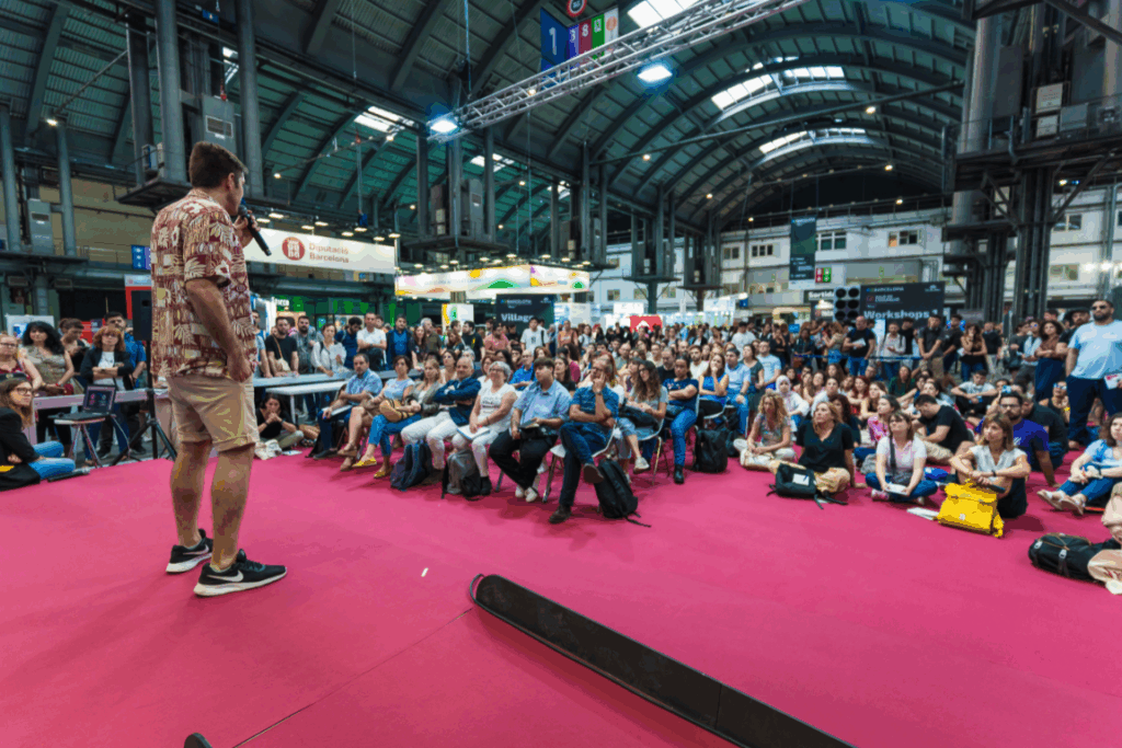 Ferran Tort ofrece una charla frente a un público masivo en un gran evento en Barcelona.