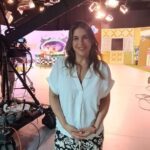 Vivianne Verschae en el set de grabación de un programa de televisión, sonriente frente a cámaras y luces de estudio.