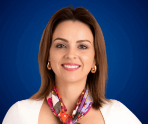 Cristina Jaramillo sonriendo, conferencista experta en liderazgo femenino, marca personal e inteligencia emocional, sobre fondo azul.