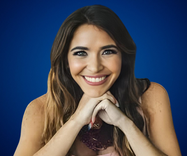 Roxana Chacón sonriendo, en fondo azul, especialista en marketing y creadora de la metodología “Ruta Lovebrand”.